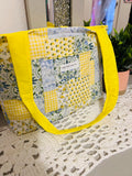 Patchwork tote bag with yellow accents on a textured surface