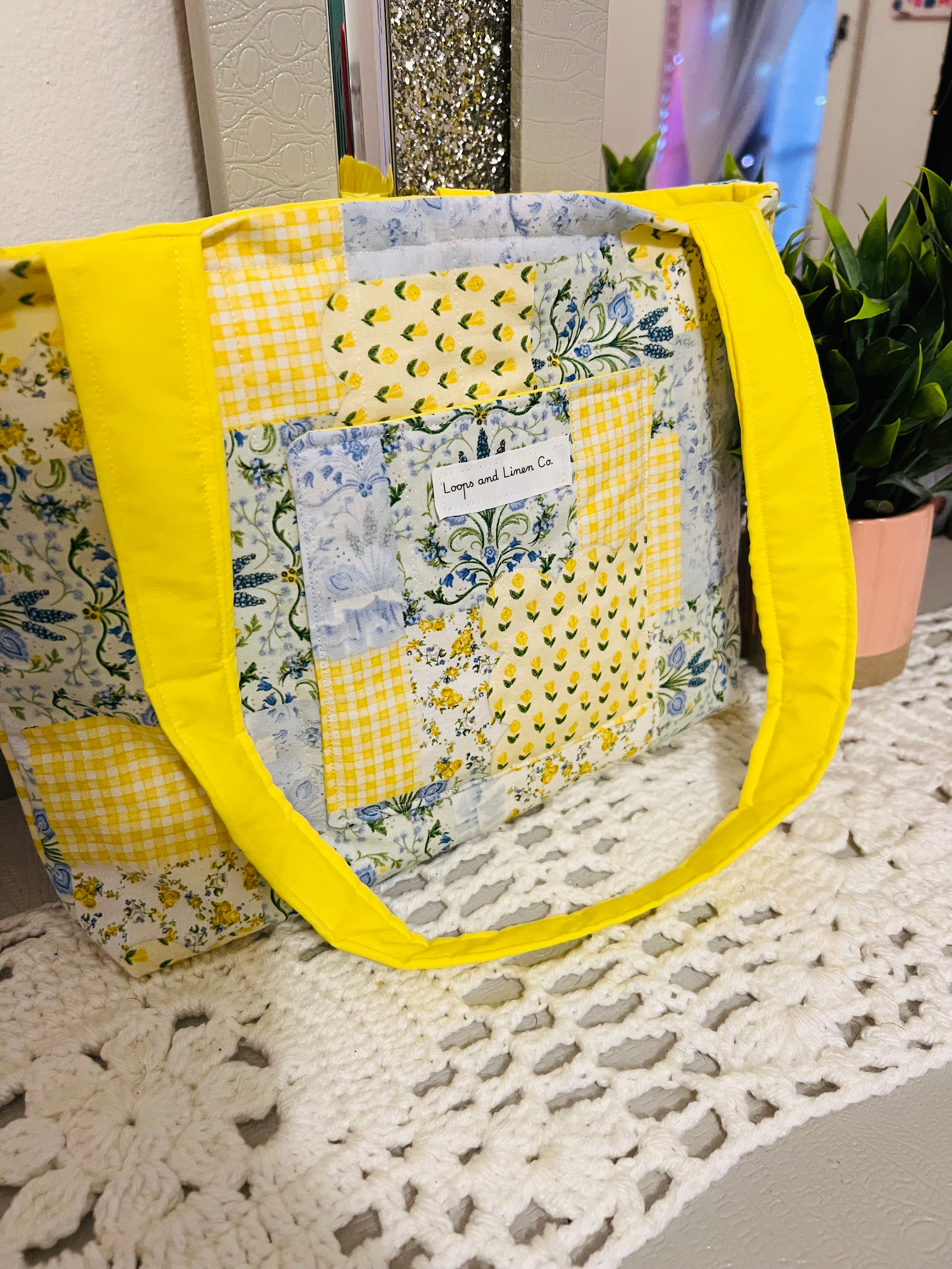 Patchwork tote bag with yellow accents on a textured surface