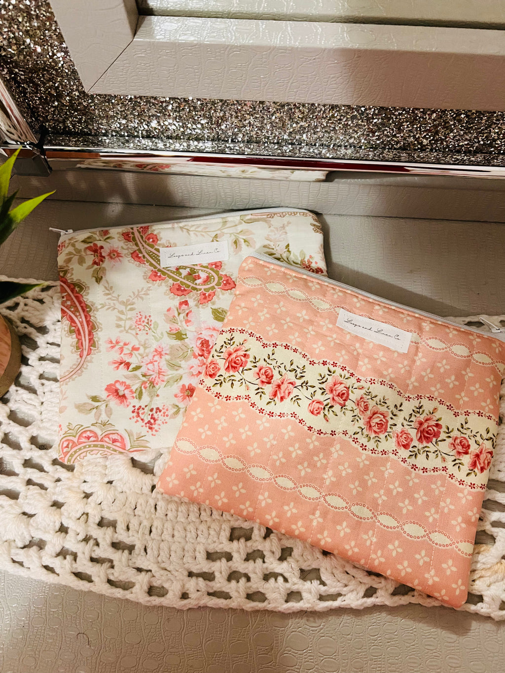 Two floral-patterned pouches on a textured surface