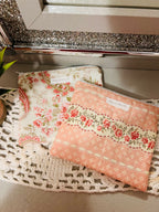 Two floral-patterned pouches on a textured surface